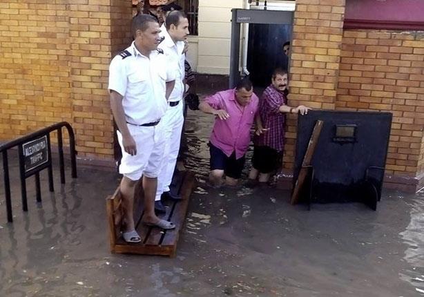 بالصور.. الأمطار تُحاصر قسم شرطة بالإسكندرية.. وأفراده يخلعون أحذيتهم لمواجهة المياه  