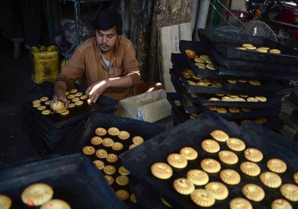 عامل أفغاني في مصنع حلويات يجهز كعك العيد، مزار شريف