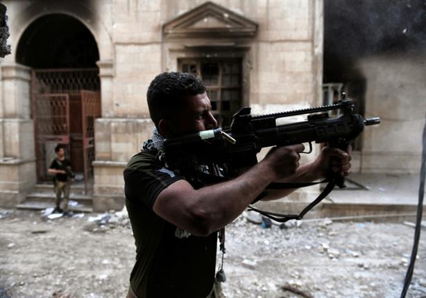 أحد أفراد القوات العراقية يطلق النار على مقاتلي داعش في 11 مارس - أ ف ب