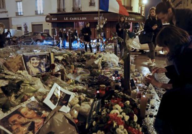 فرنسيون يضعون الشموع أمام مقهى لو كارليون، الذي تعرض للهجوم يوم الجمعة الماضي.