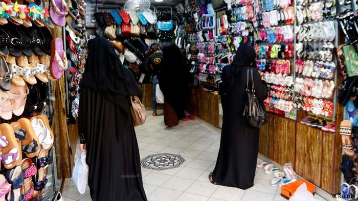 نساء يتفحصن الأحذية في محل يعرضها في الرقة.