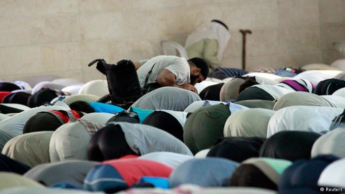 مصلون ساجدون بينهم مصلٍ على مقعد متحرك في مسجد الرقة.
