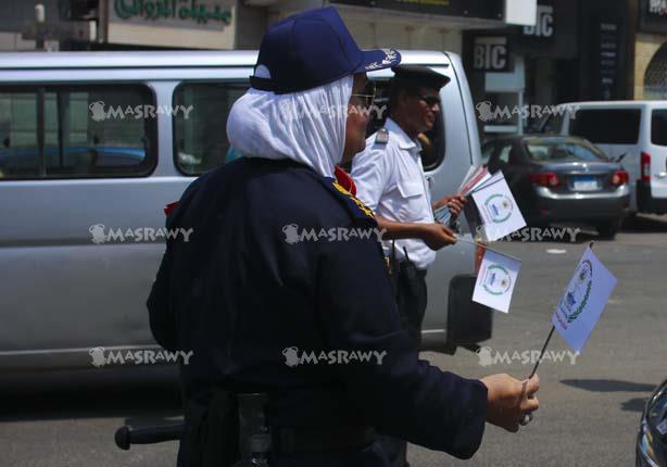أفراد الشرطة يوزعون اعلام قناة السويس على المارة