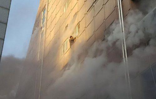 A-survivor-dangles-from-a-windowsill-as-he-waits-for-rescue-from-a-burning-building-in-Jecheon-498x315