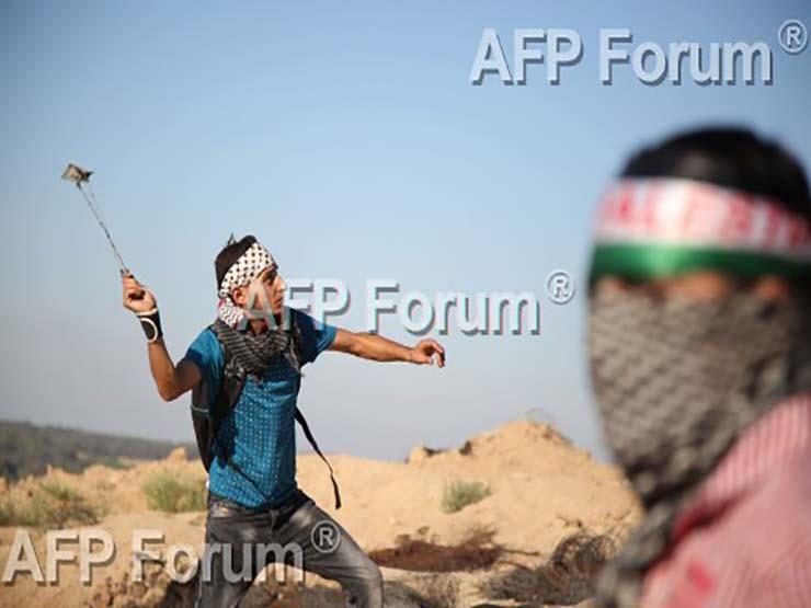 شاب فلسطيني يلقي الحجارة باتجاه جنود إسرائيليين في غزة في 4 أغسطس 2017 (أ ف ب)