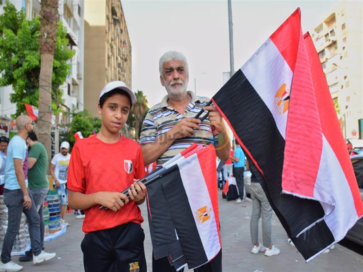 محمد يبيع أعلام مصر أمام ستاد القاهرة: «مكسب من ريحة يناير ويونيو» محمد يبيع أعلام مصر أمام ستاد القاهرة: «مكسب من ريحة يناير ويونيو»